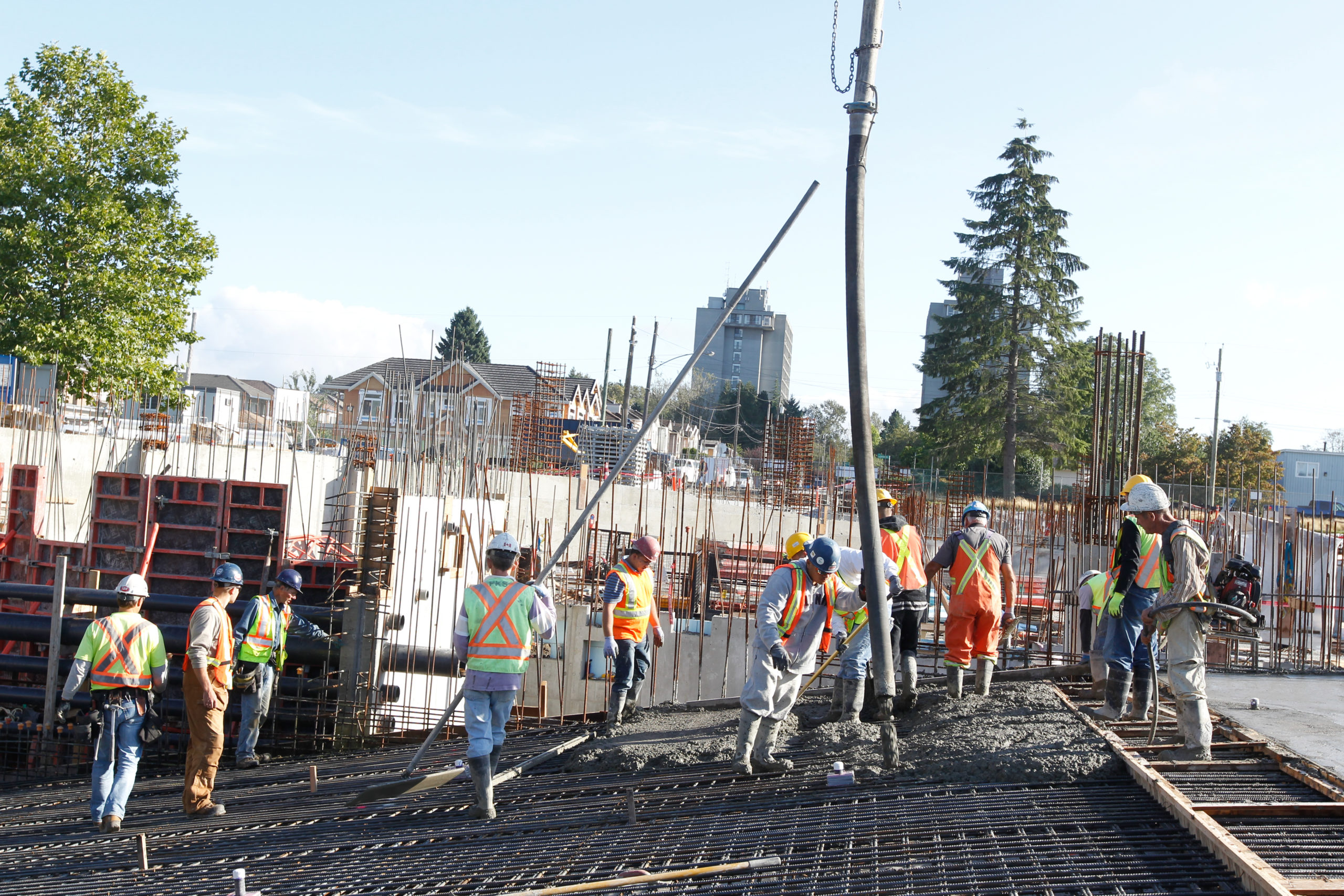 A group of construction workers at a worksite are helping to pour concrete for a project.